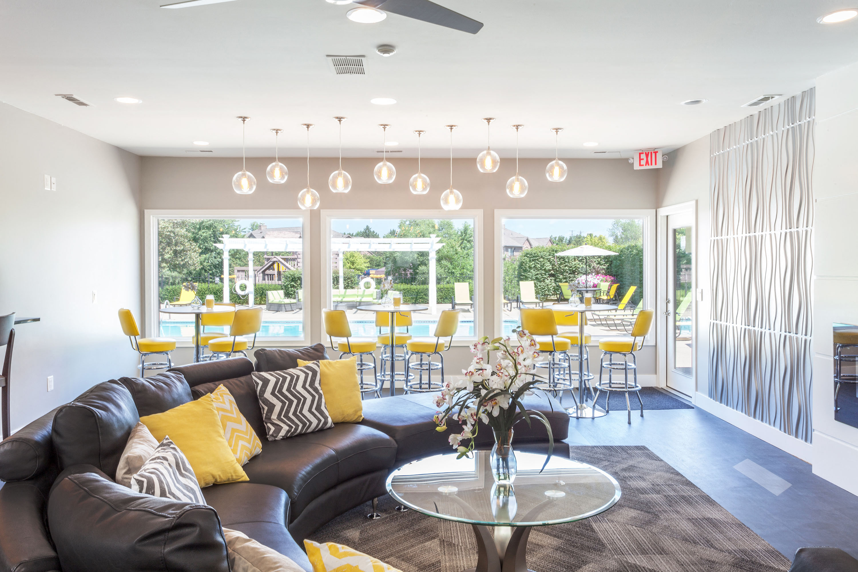 a living room with a leather couch and a table with yellow chairs